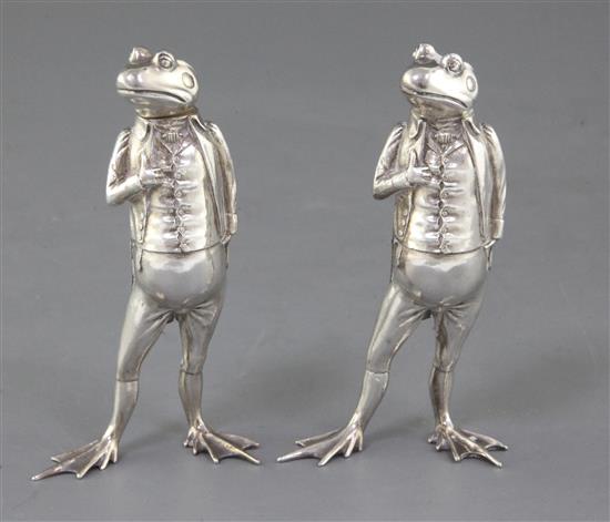 A pair of modern novelty silver pepperettes modelled as a pair of free standing frogs dressed in gentlemans clothing, 7.5 oz.